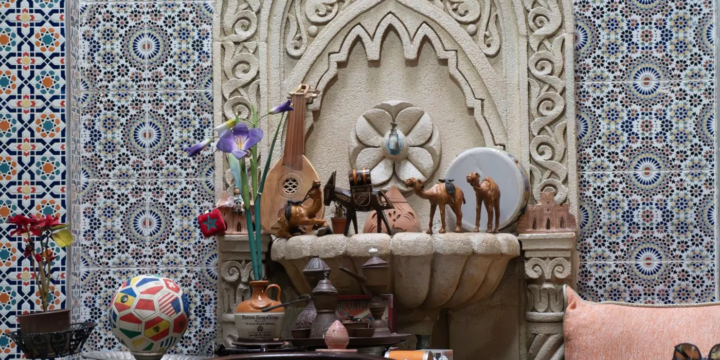 La fontaine en plâtre sculpté du patio, dans son mur de zellige