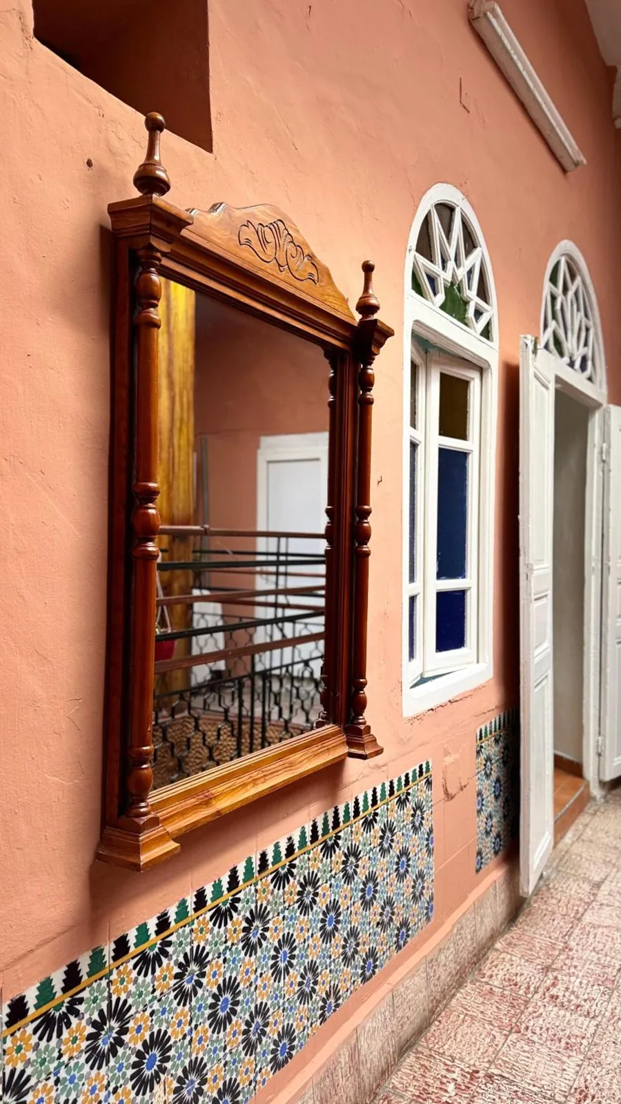 Un miroir sculpté et les fenêtres en arc de la galerie